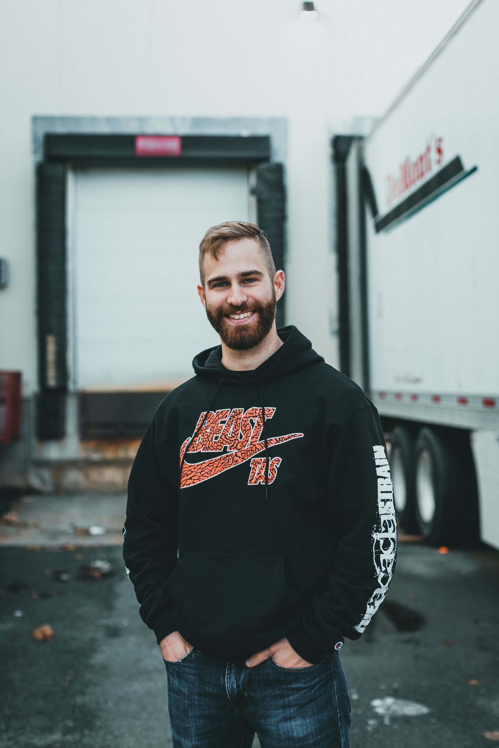 A driver standing beside his trailer at the loading dock
